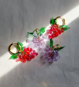 Handmade gold hoop earrings with grape charm made of red glass beads.