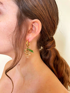 Handmade gold hoop earrings with a glass grape charm.